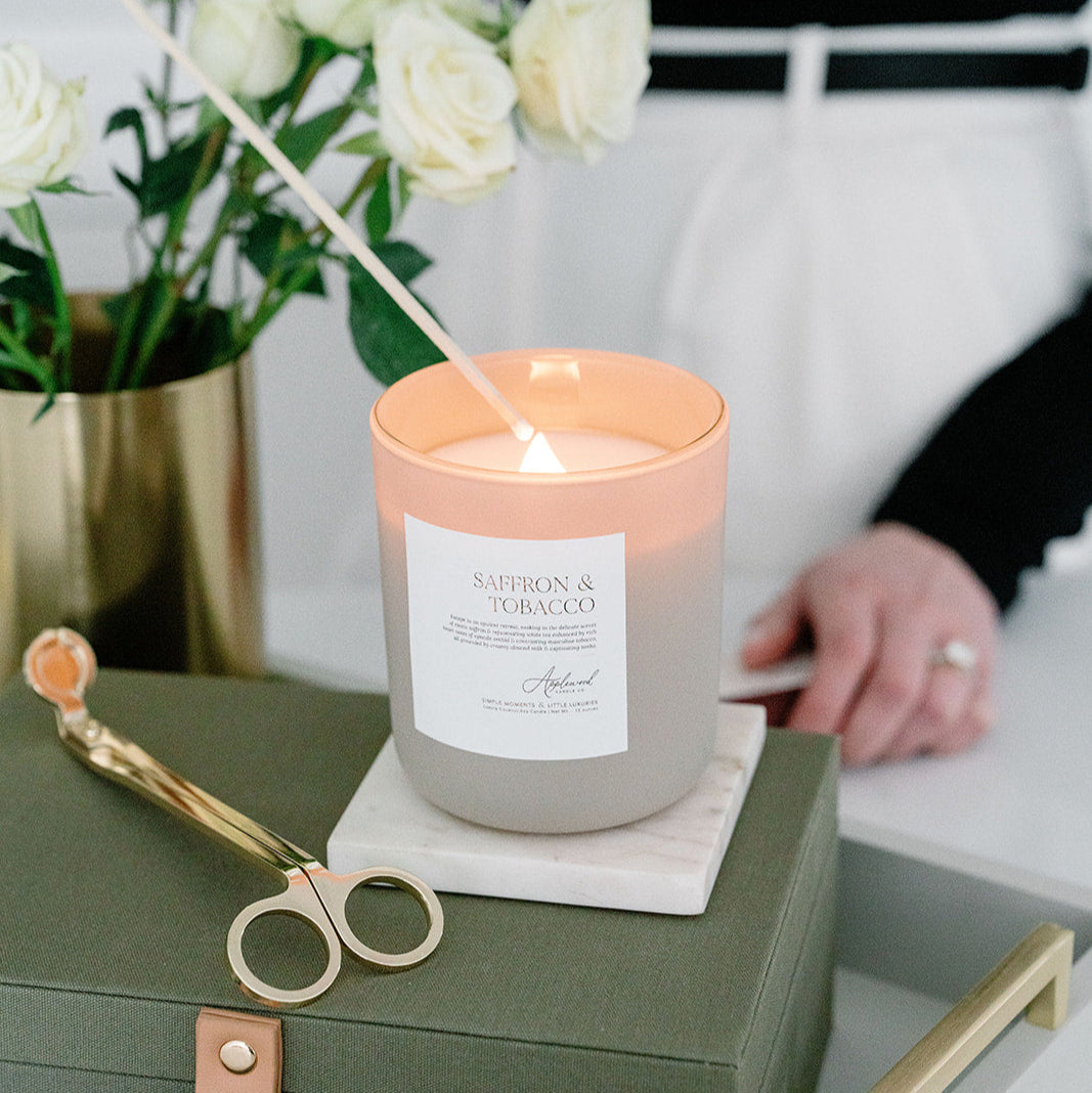 Saffron & Tobacco Candle in glass frosted jar being lit.