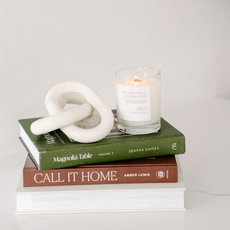 Shea Butter & Sandalwood in clear glass jar on a neutral background