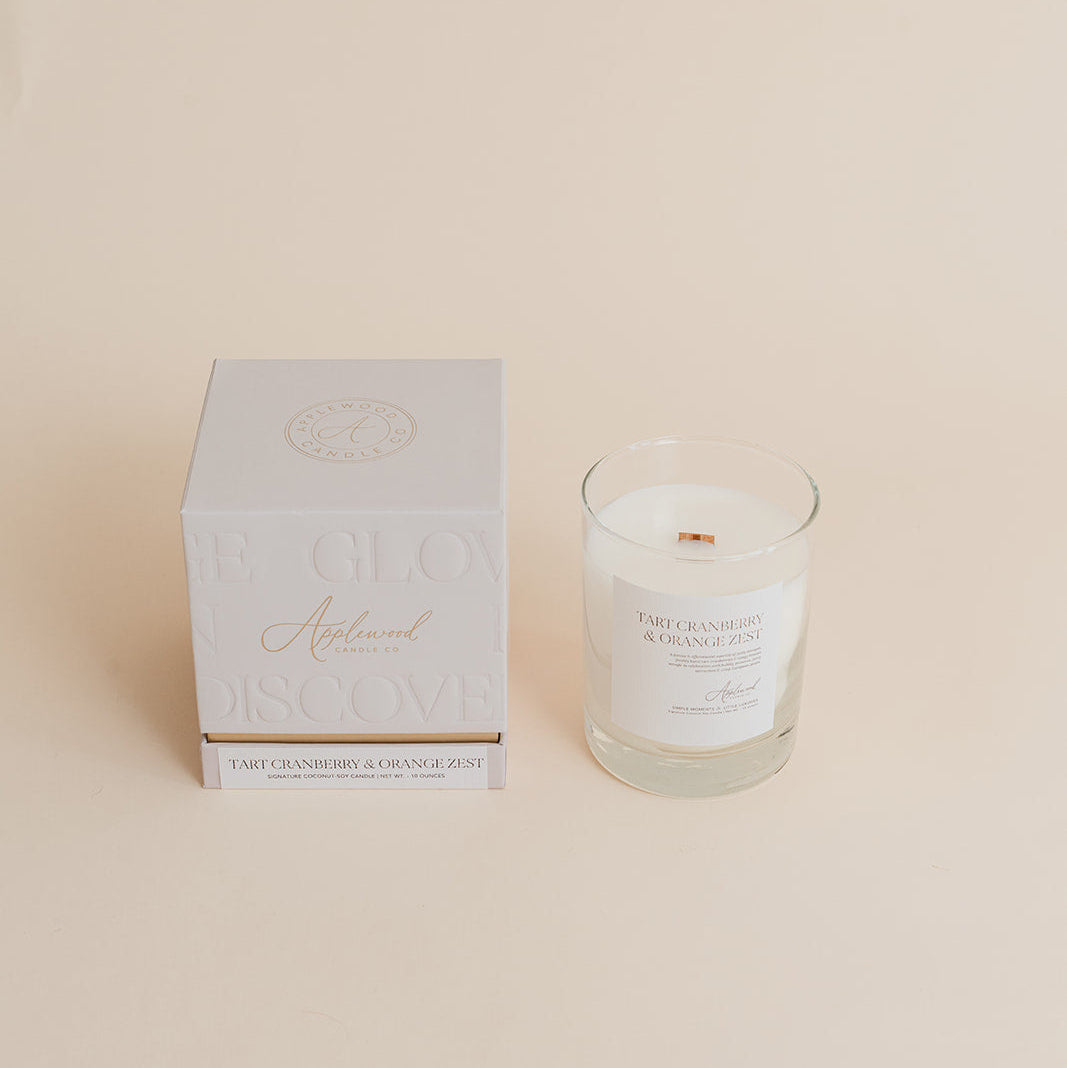 Candle and its packaging on a beige background