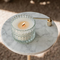 Candle in a glass holder on a marble table with a blurred background