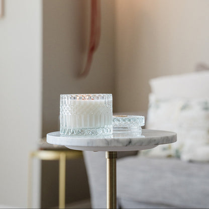 Glass candle holders on a marble side table with a blurred background