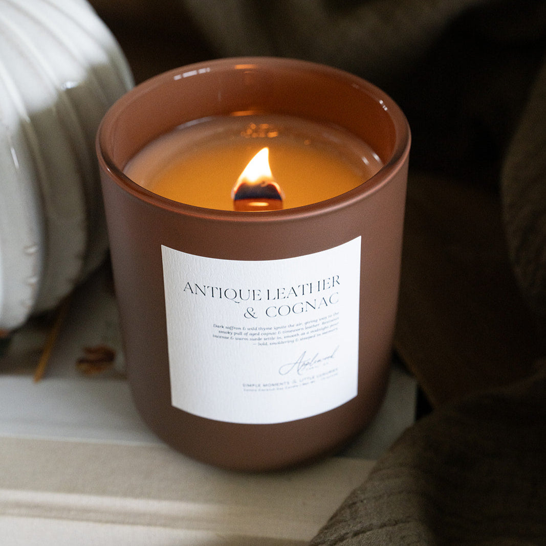 Lit Antique Leather & Cognac in brown glass jar.