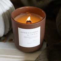 Lit Antique Leather & Cognac in brown glass jar.