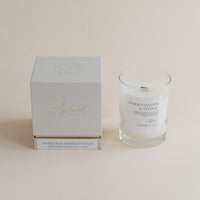 Antique Leather & Cognac candle in clear glass jar with box on beige background.