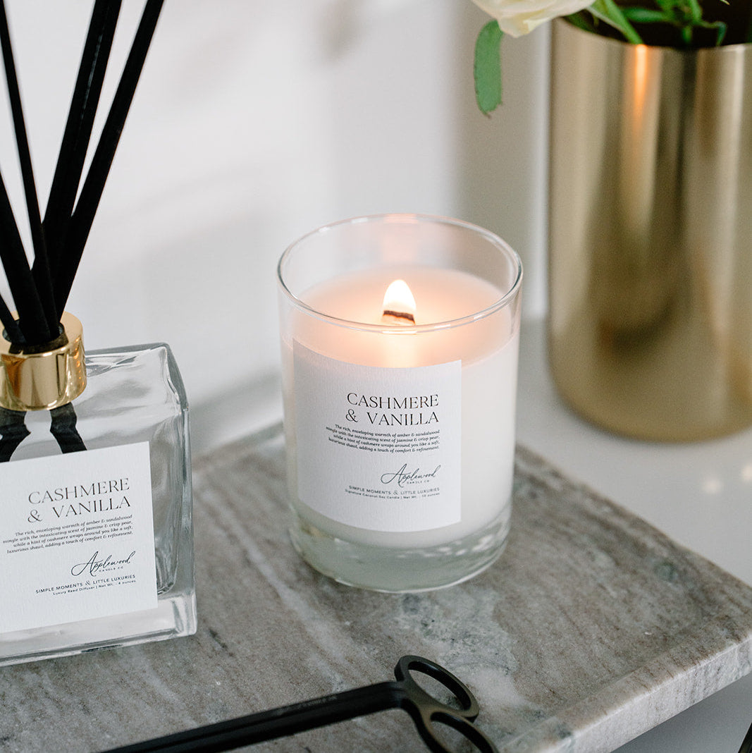 Lit Cashmere &amp; Vanilla candle in glass jar with reed diffuser and black wick trimmer