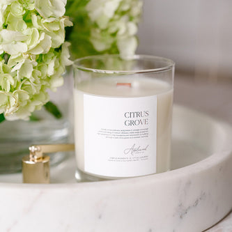Citrus Grove candle in glass jar with gold candle snuffer.