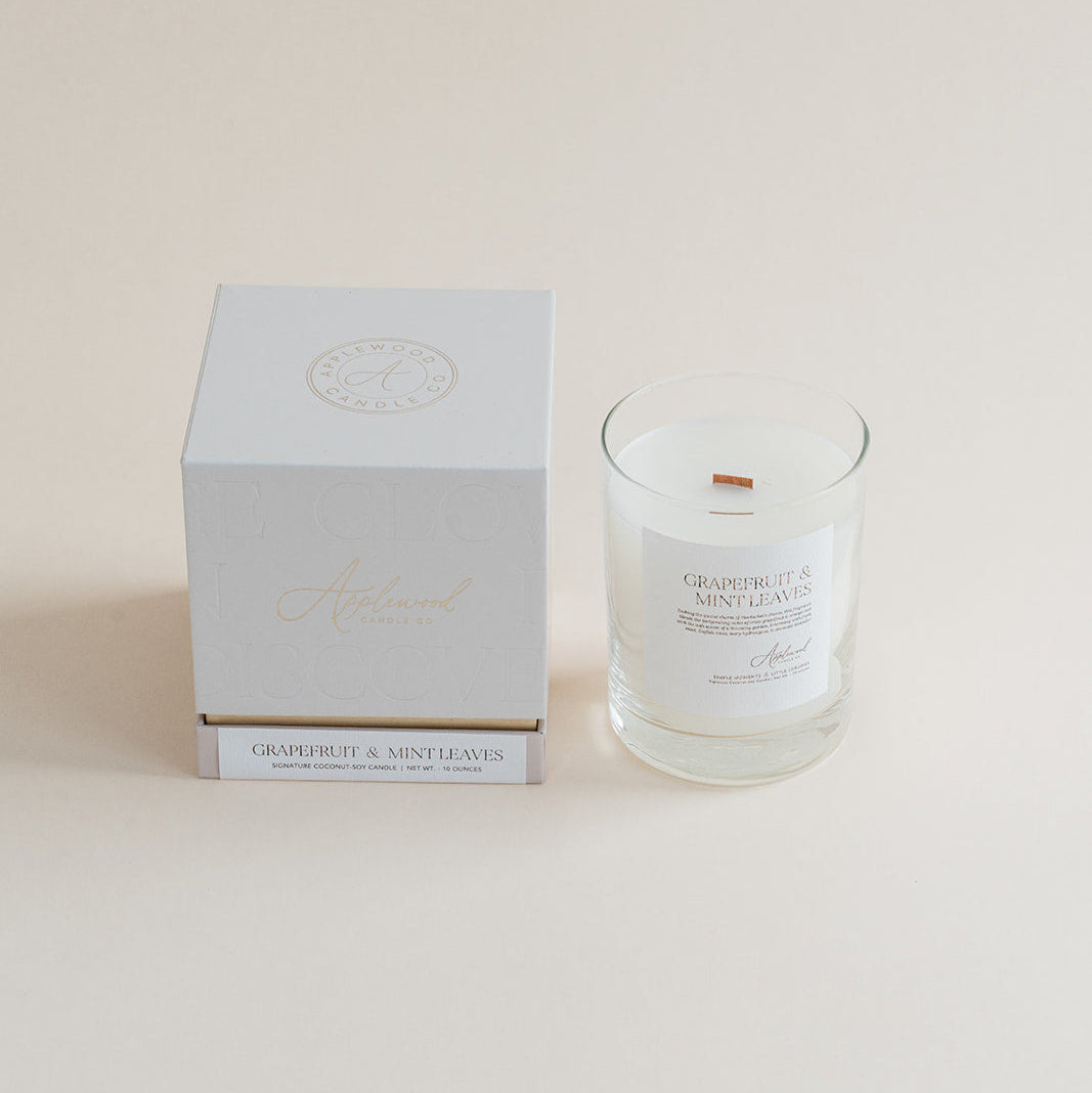 Grapefruit & Mint Leaves candle in clear glass jar with box on beige background.