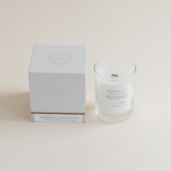 Grapefruit & Mint Leaves candle in clear glass jar with box on beige background.