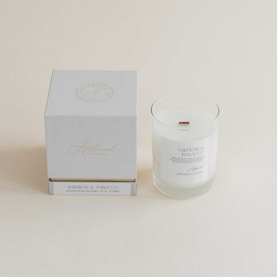 Saffron &amp; Tobacco candle glass jar with box on beige background.