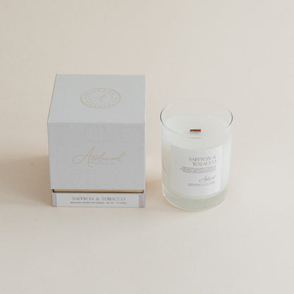 Saffron &amp; Tobacco candle glass jar with box on beige background.