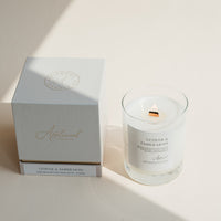 Vetiver & Ember Moss candle in clear glass jar with box on beige background.