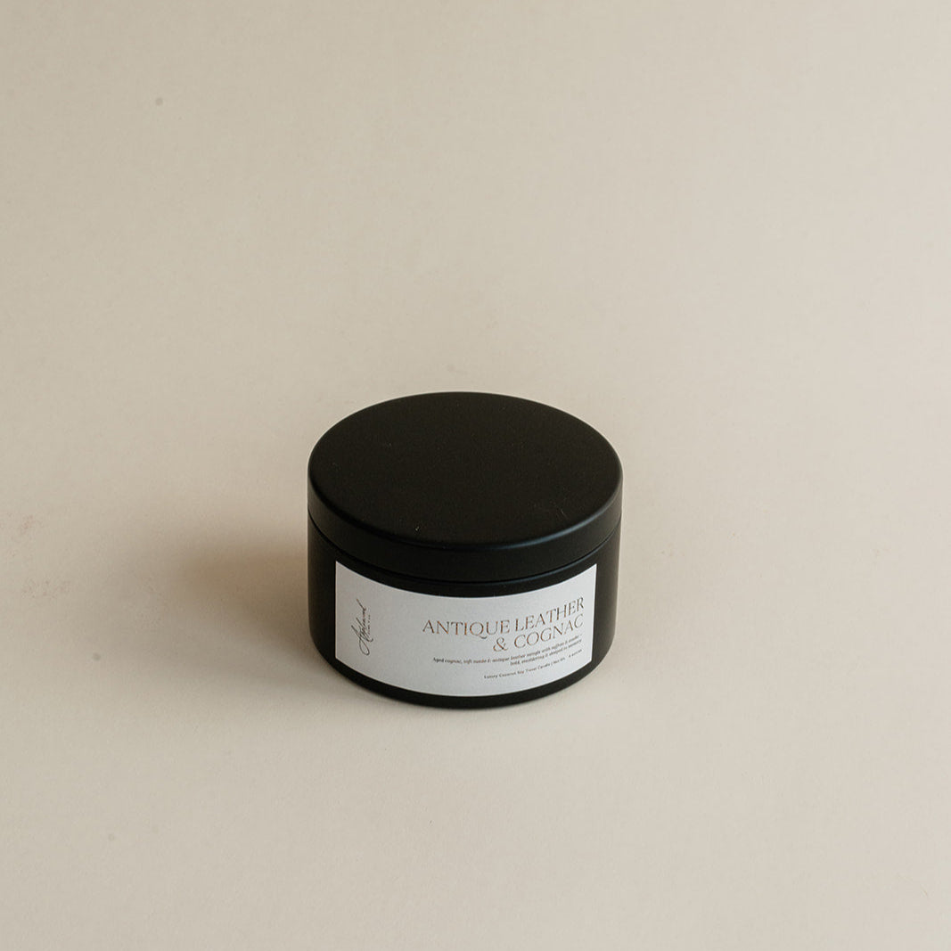 Travel Antique Leather & Cognac in tin can on beige background.