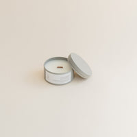 Travel Cashmere & Vanilla candle in tin can on beige background.
