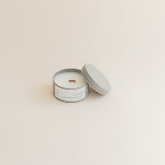 Travel Cashmere & Vanilla candle in tin can on beige background.