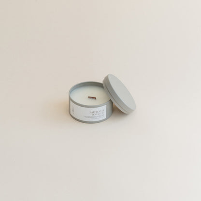 Travel Saffron &amp; Tobacco candle in tin can on beige background