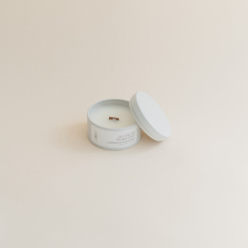 Travel Sea Salt & Teakwood candle in tin can on beige background