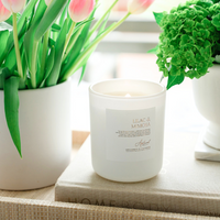 Luxury Lilac & Mimosa candle in frosted glass with plants in the background