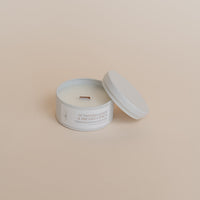 Candle in a white container with a beige background