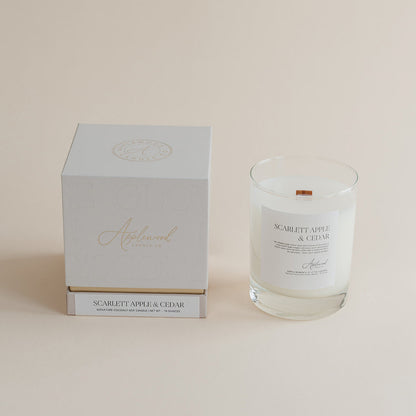 Glass candle with label and white box on a beige background