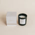 Black candle in a box on a beige background