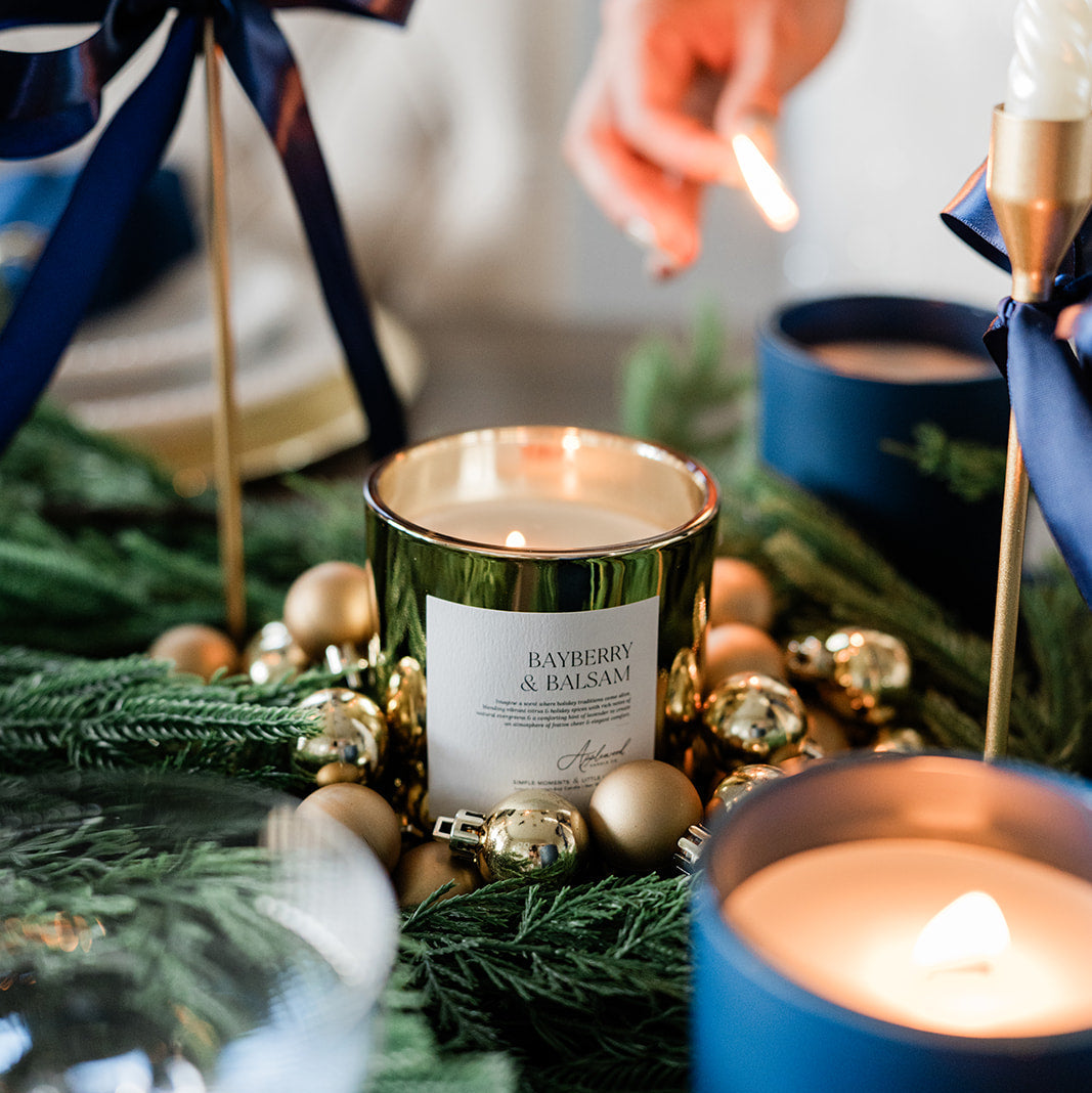 Decorative candles with greenery and ornaments on a table